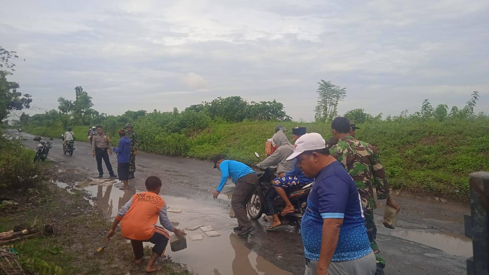 Babinsa Sekaran Bantu Warga Perbaiki Jalan Rusak