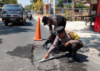 Anggota Polsek Maduran Tambal Jalan Berlubang
